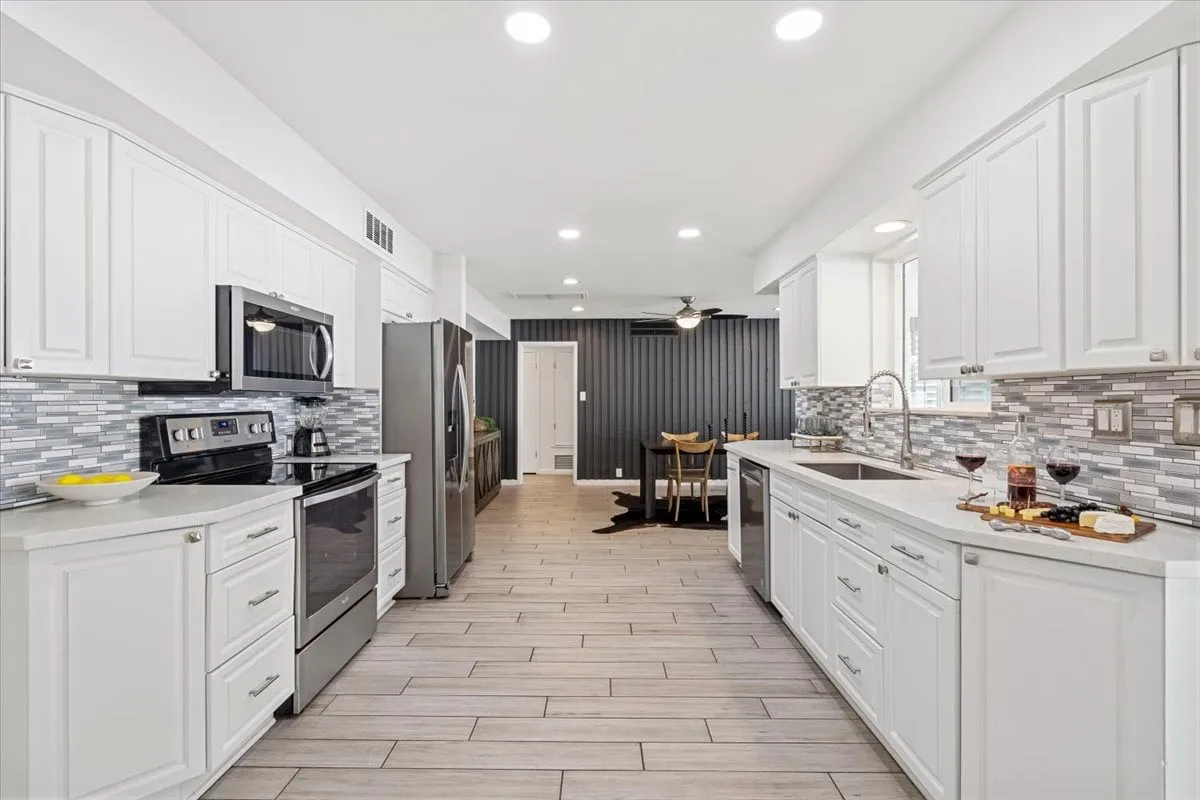 A modern kitchen featuring sleek appliances, quartz countertops, an elegant backsplash, and a connected dining area. The space is well-lit and organized, projecting an inviting and contemporary atmosphere perfect for meal preparation and easy arrivals.