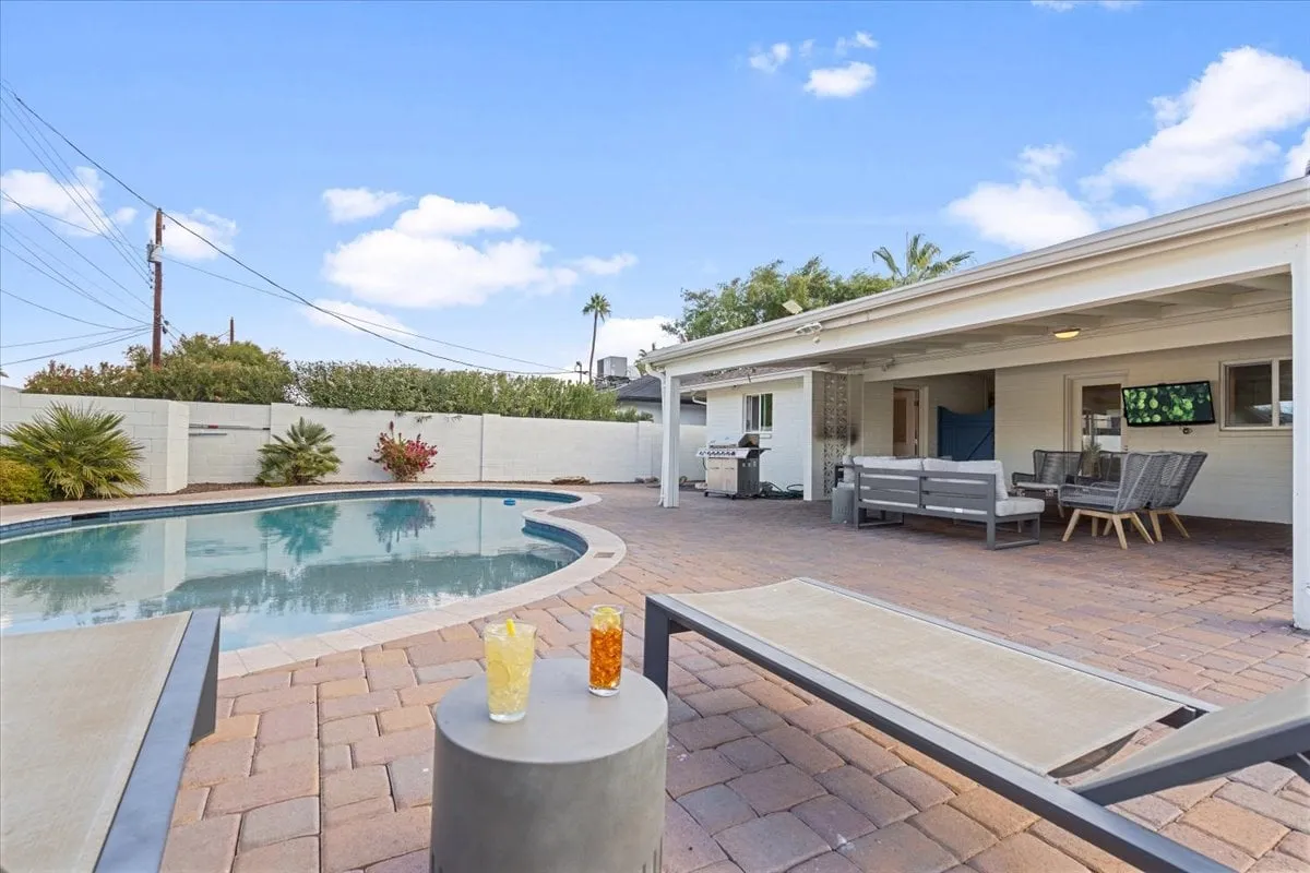 A sparkling swimming pool surrounded by lounge chairs, an outdoor seating area, and a grill under sunny skies. The setting invites relaxation, sunbathing, and social gatherings—ideal for unwinding after a round of golf.